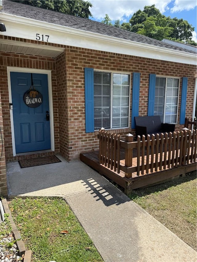 517 Lanier Cres, Portsmouth, VA 23707 - view of exterior entry featuring brick siding, a wooden deck, and a shingled roof