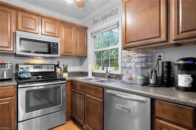 1812 Bancroft Dr, Hampton, VA 23663 - kitchen featuring appliances with stainless steel finishes, a sink, dark countertops, crown molding, and brown cabinetry