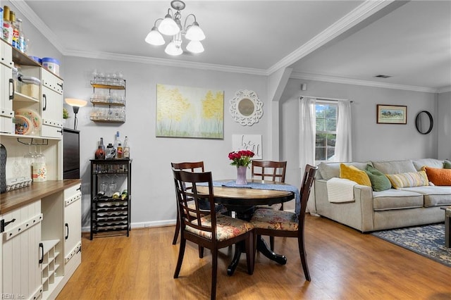 1812 Bancroft Dr, Hampton, VA 23663 - dining room featuring light wood-style flooring, ornamental molding, a chandelier, and baseboards
