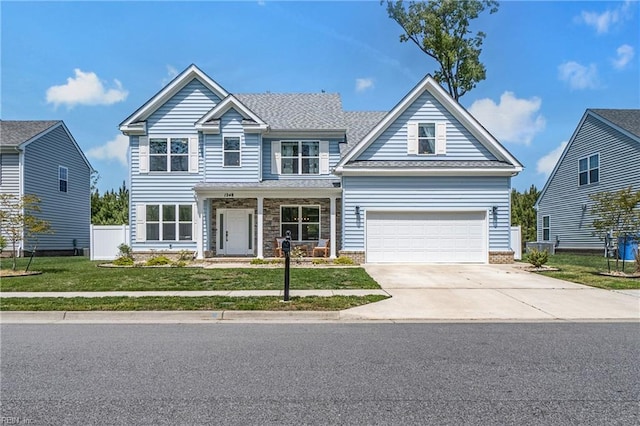view of front of house with driveway, an attached garage, and a porch