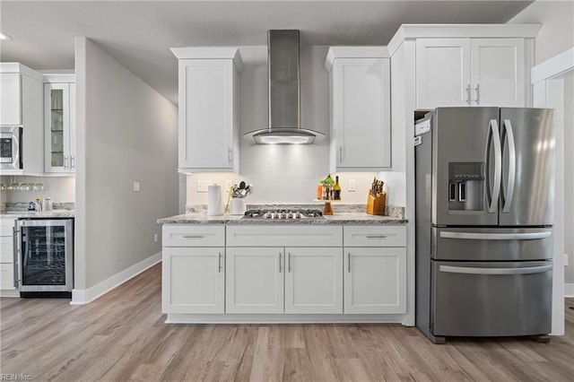kitchen featuring stainless steel appliances, wine cooler, wall chimney exhaust hood, white cabinets, and recessed lighting