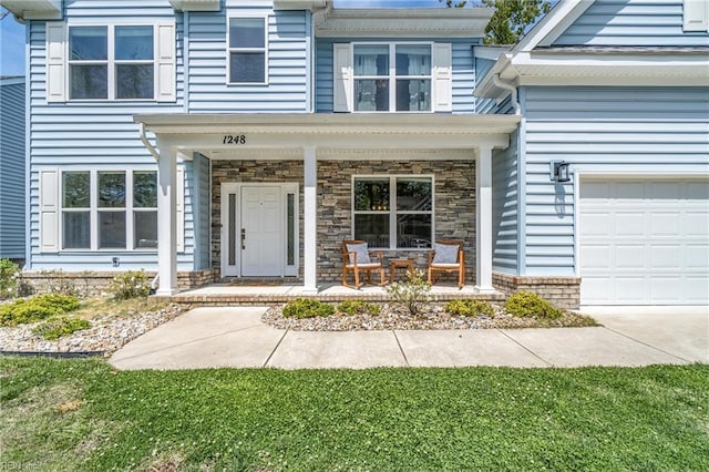 entrance to property with covered porch and a garage