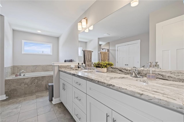full bathroom featuring a garden tub, double vanity, and tile patterned flooring