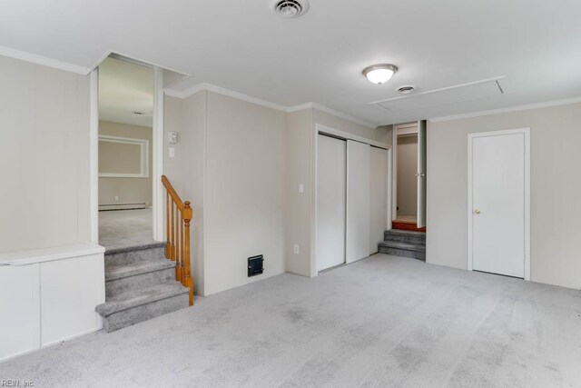 unfurnished bedroom featuring carpet, attic access, a baseboard heating unit, and crown molding