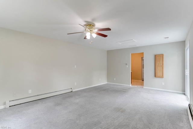 carpeted spare room with a baseboard heating unit, a ceiling fan, baseboards, and attic access