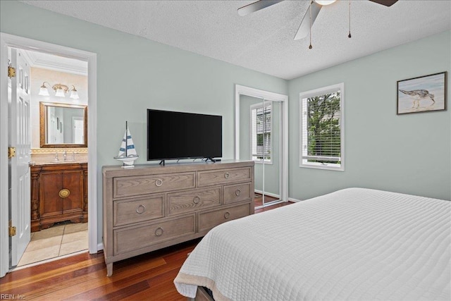 609 S Atlantic Ave, Virginia Beach, VA 23451 - bedroom with wood finished floors, a sink, a textured ceiling, connected bathroom, and a ceiling fan