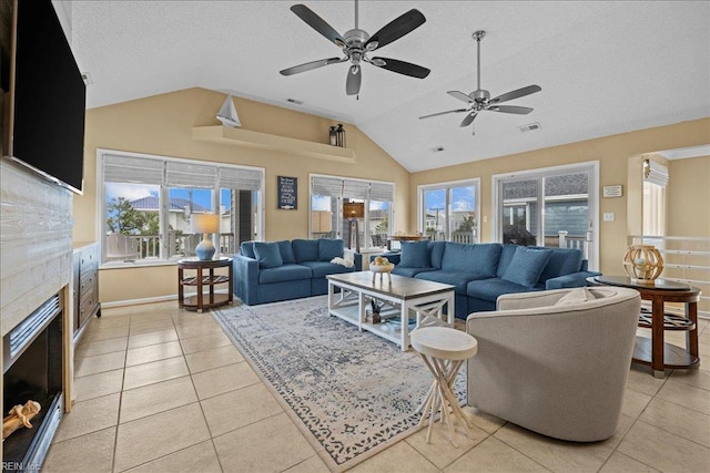 609 S Atlantic Ave, Virginia Beach, VA 23451 - living room with vaulted ceiling, ceiling fan, a tiled fireplace, light tile patterned floors, and plenty of natural light