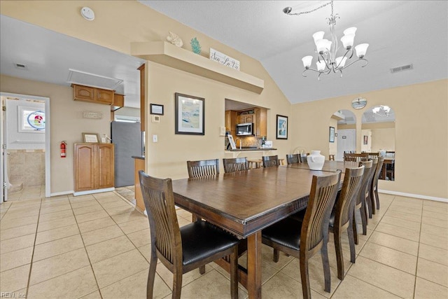 609 S Atlantic Ave, Virginia Beach, VA 23451 - dining room featuring a chandelier, light tile patterned floors, lofted ceiling, arched walkways, and baseboards