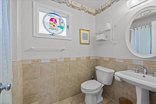 609 S Atlantic Ave, Virginia Beach, VA 23451 - full bath featuring tile walls, toilet, a wainscoted wall, tile patterned floors, and a sink