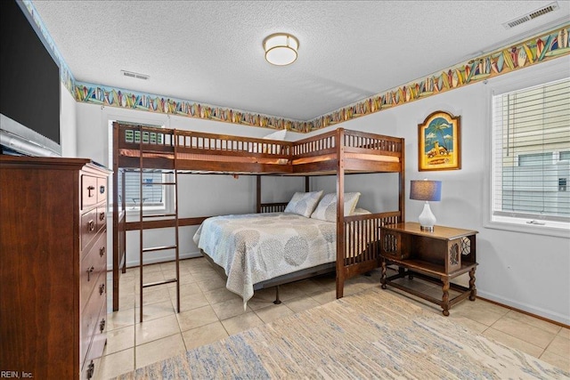 609 S Atlantic Ave, Virginia Beach, VA 23451 - tiled bedroom with a textured ceiling, multiple windows, and baseboards