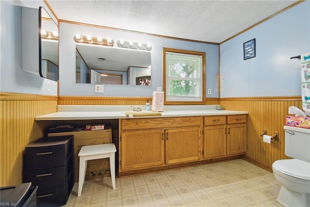 1237 Peachtree Dr, Suffolk, VA 23434 - bathroom with wainscoting, tile patterned floors, toilet, ornamental molding, and a textured ceiling