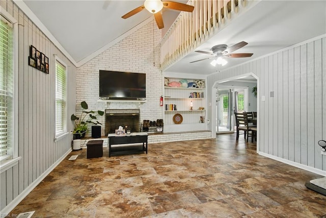 1237 Peachtree Dr, Suffolk, VA 23434 - living room featuring a ceiling fan, vaulted ceiling, a brick fireplace, stone finish flooring, and arched walkways