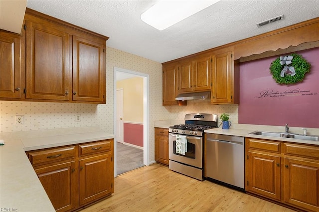 12 Critzos Ct, Hampton, VA 23669 - kitchen with appliances with stainless steel finishes, a sink, light countertops, light wood-style floors, and brown cabinetry
