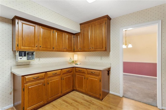 12 Critzos Ct, Hampton, VA 23669 - kitchen featuring light wood finished floors, wallpapered walls, light countertops, and brown cabinets
