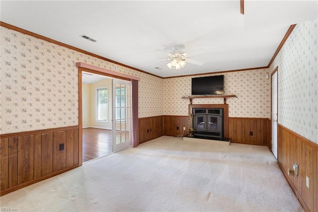 12 Critzos Ct, Hampton, VA 23669 - unfurnished living room featuring wooden walls, a wainscoted wall, ornamental molding, ceiling fan, and light carpet
