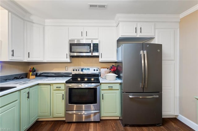 kitchen with appliances with stainless steel finishes, green cabinets, light countertops, dark wood finished floors, and white cabinetry