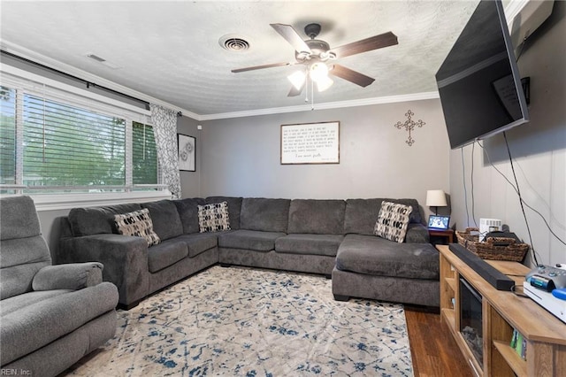 living area featuring wood finished floors, ceiling fan, and crown molding