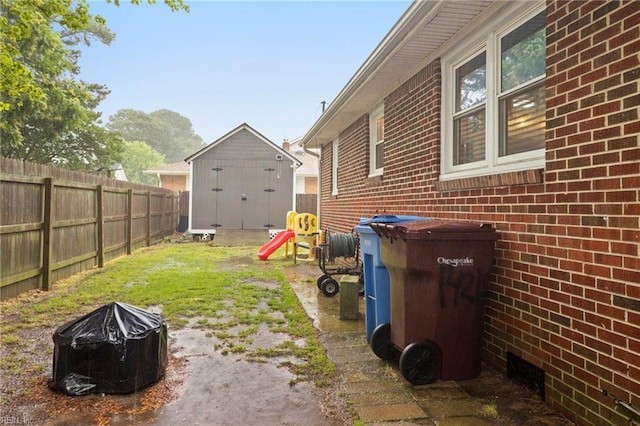 view of yard featuring fence, a fire pit, and an outdoor structure