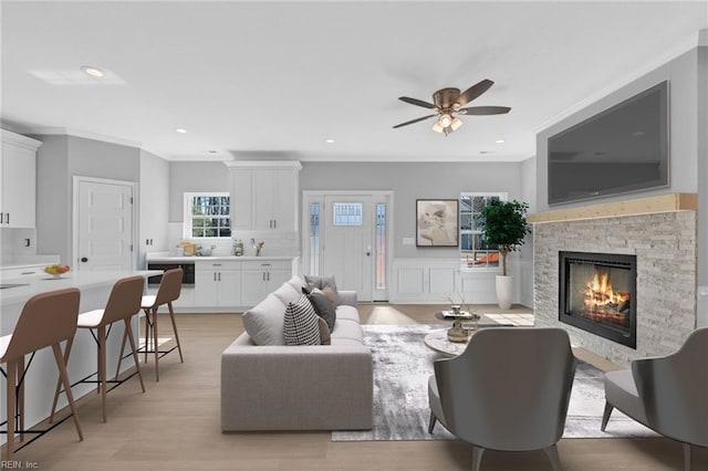 4780 Seal Ln, Virginia Beach, VA 23450 - living room featuring crown molding, ceiling fan, a stone fireplace, light wood-style floors, and recessed lighting