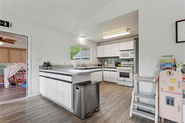 13 Dandy Point Rd, Hampton, VA 23664 - kitchen featuring white appliances, a peninsula, white cabinets, light wood-type flooring, and lofted ceiling