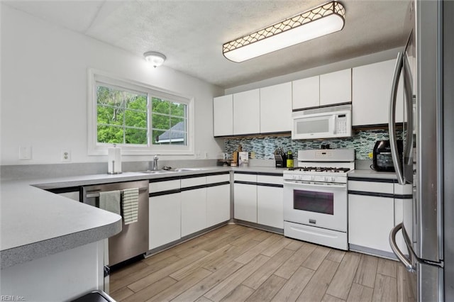 13 Dandy Point Rd, Hampton, VA 23664 - kitchen featuring appliances with stainless steel finishes, white cabinets, light wood-type flooring, tasteful backsplash, and a textured ceiling