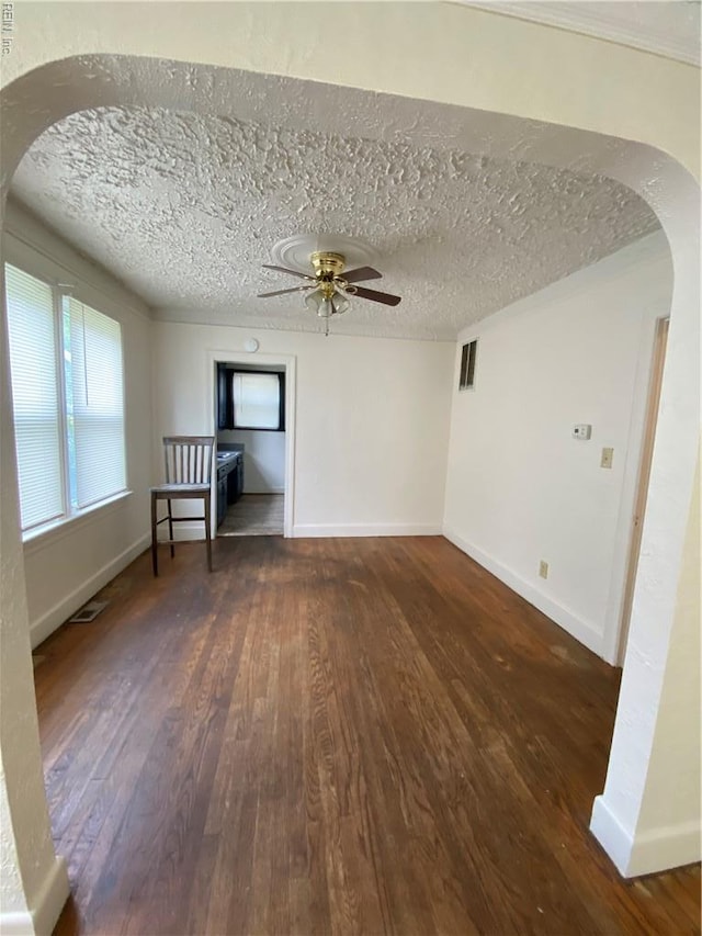 3814 Lenoir Cir, Norfolk, VA 23513 - unfurnished living room featuring arched walkways, wood finished floors, a ceiling fan, baseboards, and a textured ceiling