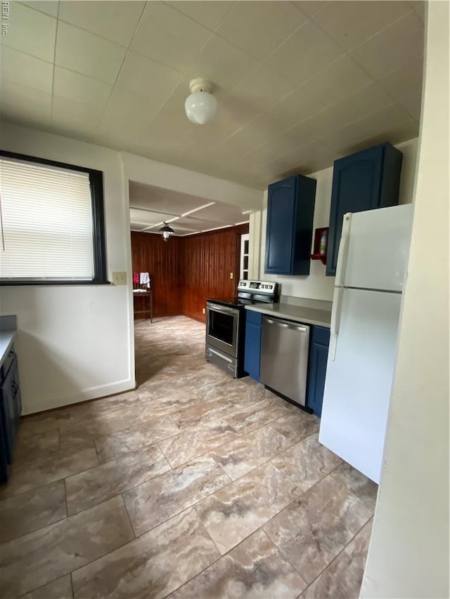 3814 Lenoir Cir, Norfolk, VA 23513 - kitchen with blue cabinets, stainless steel appliances, wood walls, and light countertops