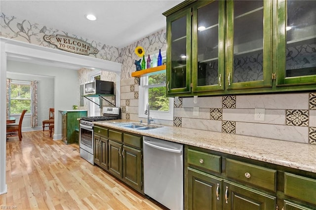 253 S George Washington Hwy, Chesapeake, VA 23323 - kitchen with appliances with stainless steel finishes, a sink, green cabinetry, light wood-type flooring, and tasteful backsplash