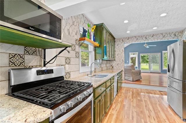 253 S George Washington Hwy, Chesapeake, VA 23323 - kitchen with stainless steel appliances, green cabinets, a sink, a ceiling fan, and light wood-type flooring