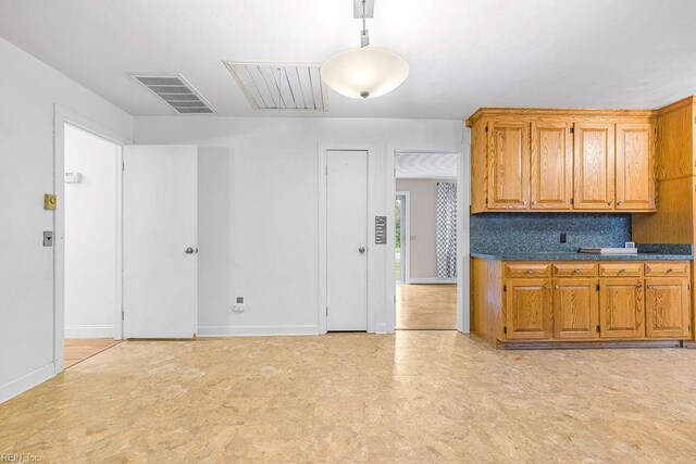 27195 Dogwood Bend Rd, Franklin, VA 23851 - kitchen with light flooring, baseboards, brown cabinets, and dark countertops