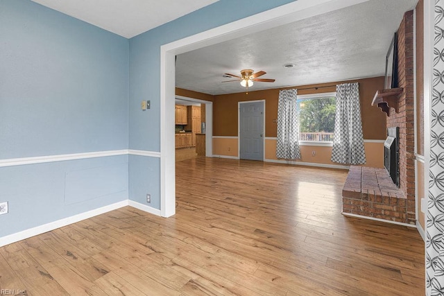 27195 Dogwood Bend Rd, Franklin, VA 23851 - unfurnished living room featuring a brick fireplace, ceiling fan, baseboards, and light wood-style flooring