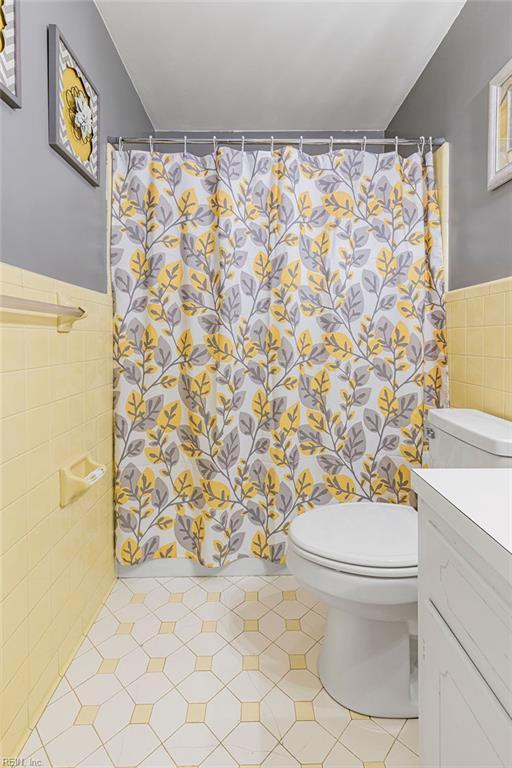 27195 Dogwood Bend Rd, Franklin, VA 23851 - full bathroom with tile walls, toilet, a wainscoted wall, vanity, and a shower with curtain