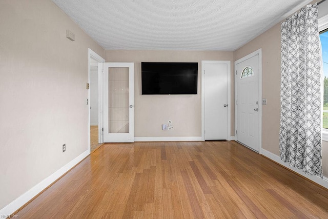 27195 Dogwood Bend Rd, Franklin, VA 23851 - unfurnished living room with light wood-style floors, baseboards, and a textured ceiling