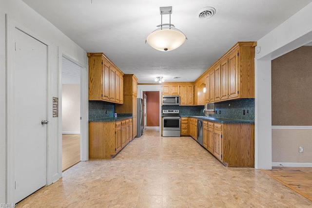 27195 Dogwood Bend Rd, Franklin, VA 23851 - kitchen with appliances with stainless steel finishes, backsplash, and brown cabinetry