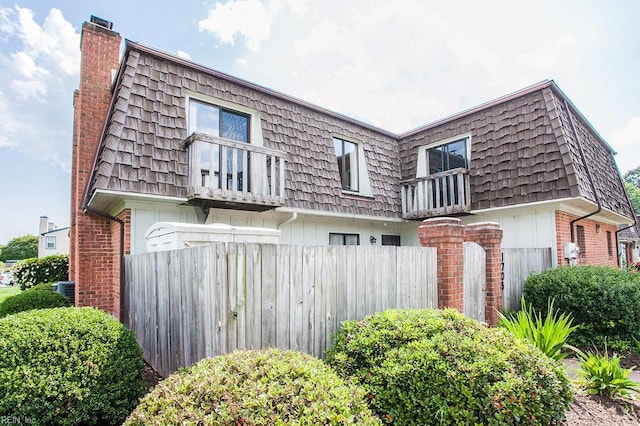 1705 Ocean Bay Dr, Virginia Beach, VA 23454 - view of front of property with a chimney, brick siding, mansard roof, and central air condition unit