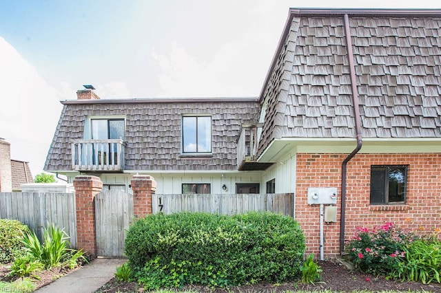 1705 Ocean Bay Dr, Virginia Beach, VA 23454 - view of front facade featuring mansard roof, brick siding, and a chimney