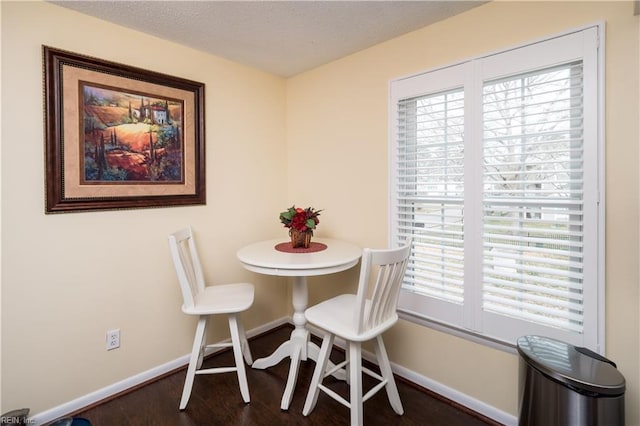 dining area with baseboards, wood finished floors, and a textured ceiling