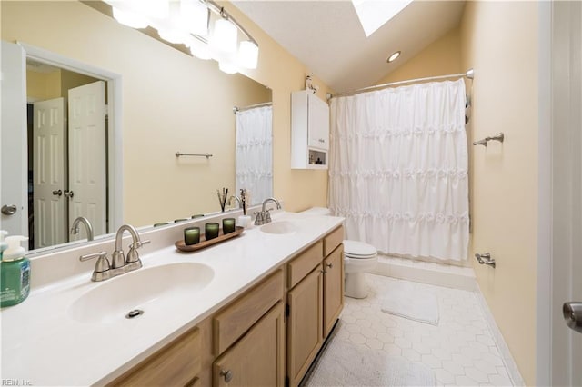 full bath featuring a skylight, toilet, double vanity, lofted ceiling, and tile patterned flooring