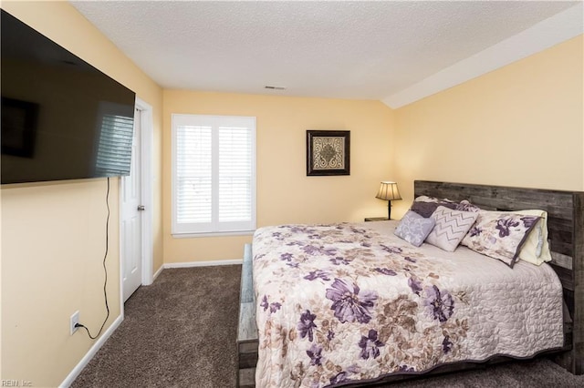 bedroom with dark carpet, baseboards, a textured ceiling, and vaulted ceiling