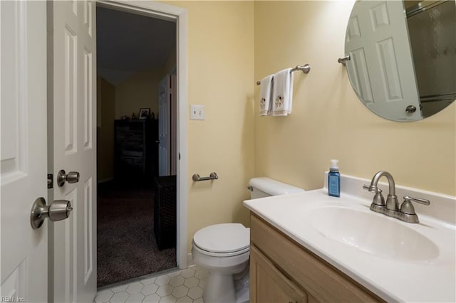 bathroom featuring toilet, vanity, and tile patterned flooring