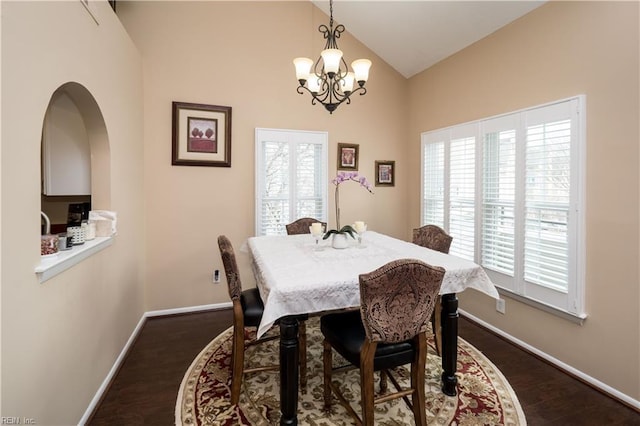 dining area with a chandelier, plenty of natural light, high vaulted ceiling, and baseboards