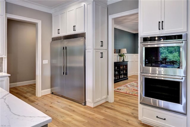 116 Formby, Williamsburg, VA 23188 - kitchen with stainless steel appliances, crown molding, light wood finished floors, light stone counters, and white cabinets