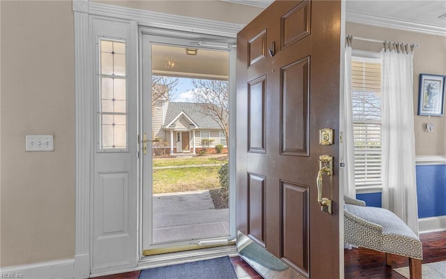 entryway with baseboards, ornamental molding, and wood finished floors