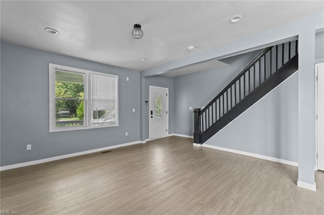 entryway with wood finished floors, stairs, and baseboards
