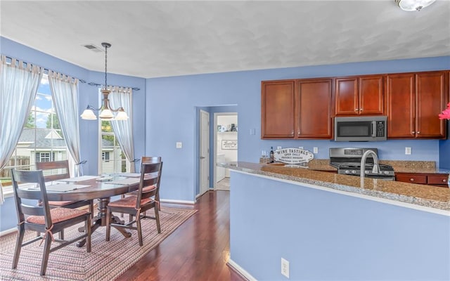 2230 Angler Ln, Chesapeake, VA 23323 - kitchen with appliances with stainless steel finishes, dark wood-type flooring, baseboards, light stone countertops, and hanging light fixtures