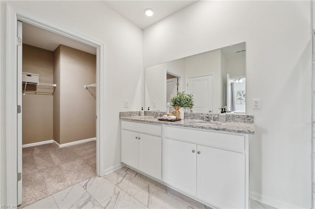 104 Genoa Dr, Elizabeth City, NC 27909 - bathroom featuring a spacious closet, double vanity, baseboards, and marble finish flooring