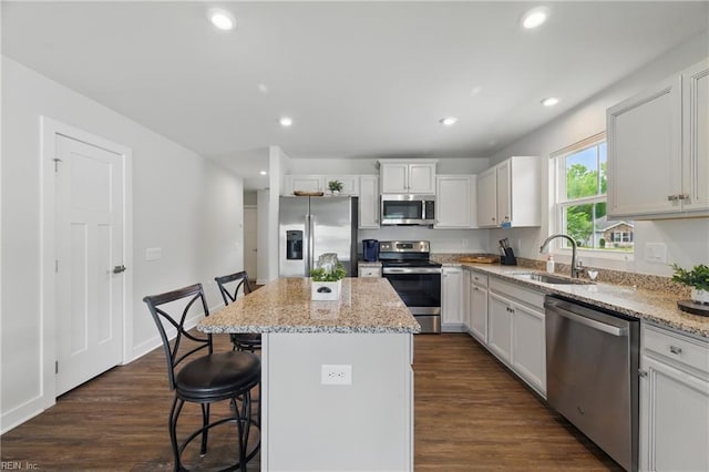 6729 Nolan Run, Gloucester, VA 23061 - kitchen with appliances with stainless steel finishes, a sink, a center island, a breakfast bar, and light stone countertops