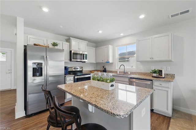 6729 Nolan Run, Gloucester, VA 23061 - kitchen featuring stainless steel appliances, a sink, a kitchen island, baseboards, and a breakfast bar