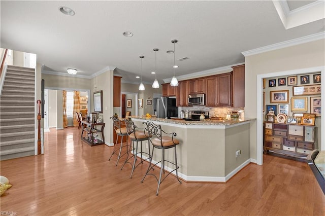 2968 Elegance Ln, Virginia Beach, VA 23456 - kitchen with appliances with stainless steel finishes, brown cabinetry, tasteful backsplash, a kitchen breakfast bar, and light wood finished floors