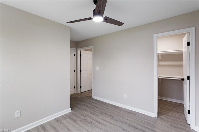 503 Middlesex St, Norfolk, VA 23523 - unfurnished bedroom featuring wood finished floors, a walk in closet, baseboards, a closet, and a ceiling fan